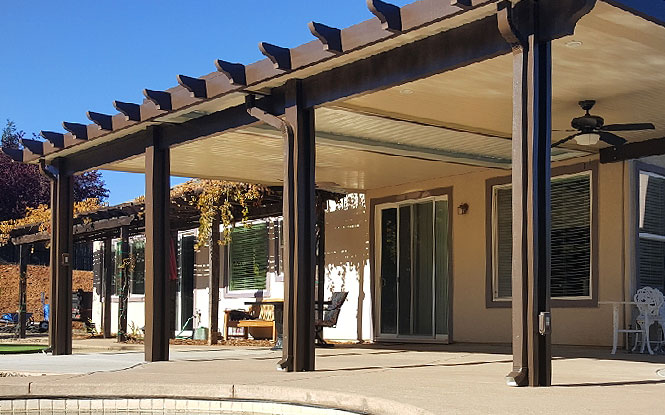 Covered patio creates an inviting outdoor space next to a refreshing pool.