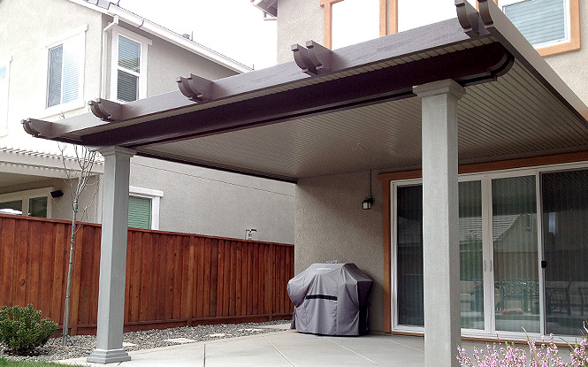 Shaded patio with pergola, grill, and sliding glass doors, perfect for indoor-outdoor living.