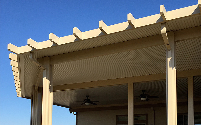 A shaded patio with a pergola and ceiling fans provides a relaxing retreat on a sunny day.